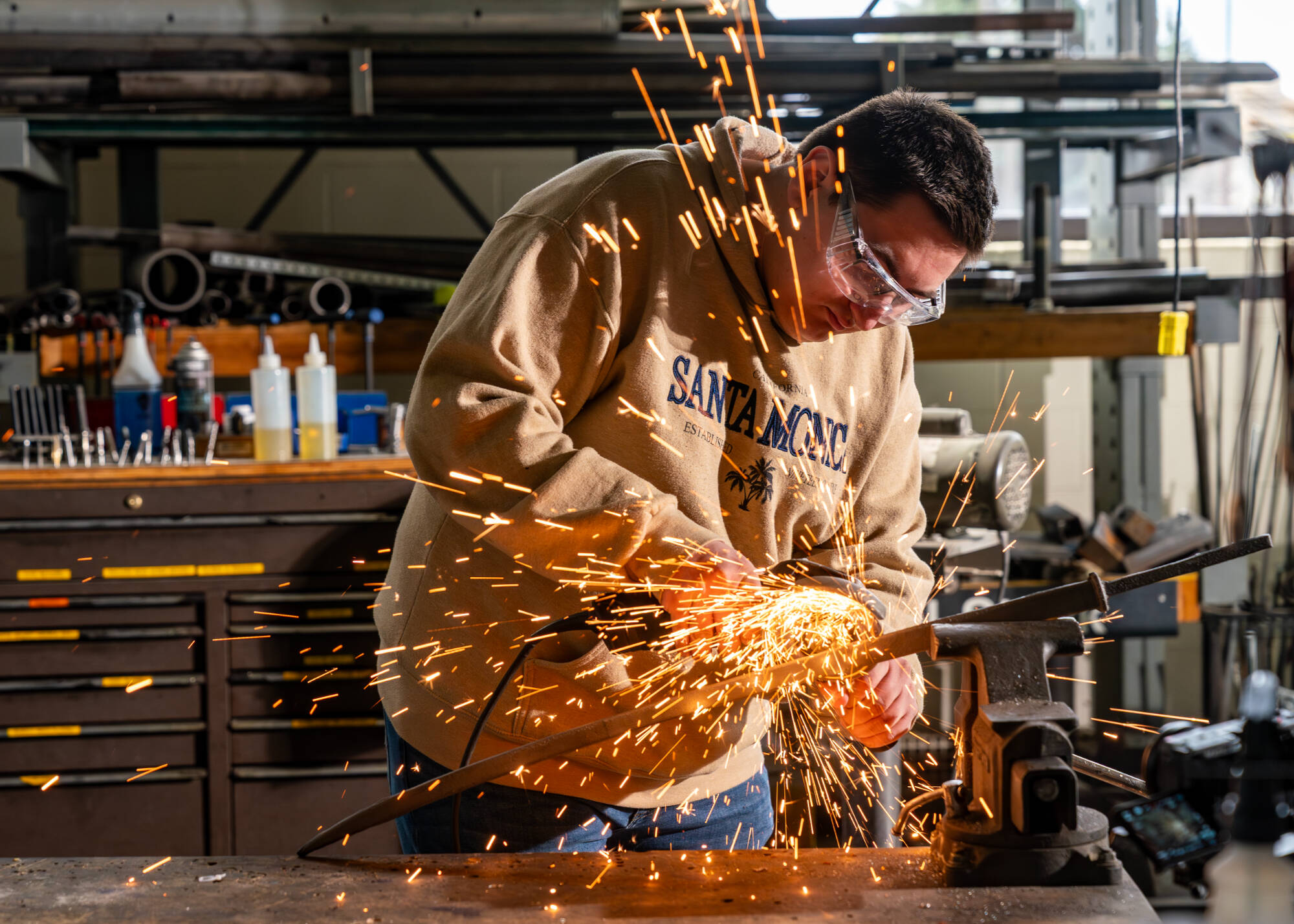 Sparks fly as mechanical engineering major Scott Strayer grinds a sword for a video crew at the Kennedy Hall of Engineering on March 21. Workaholic Productions is producing a video of GVSU students making a sword for the Cast in Steel competition. (Pho...